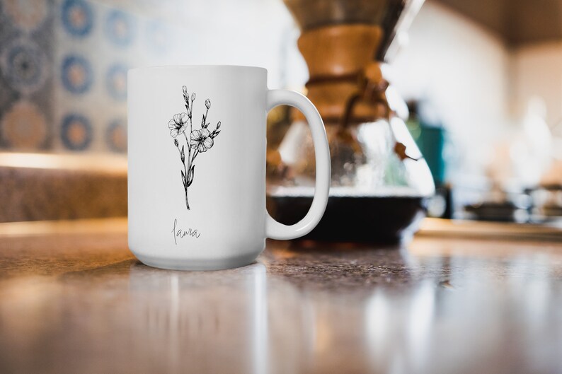 Puede incluir: Taza de cer&aacute;mica blanca con un dibujo de l&iacute;nea negra de una flor y la palabra "lama" impresa en la parte inferior.