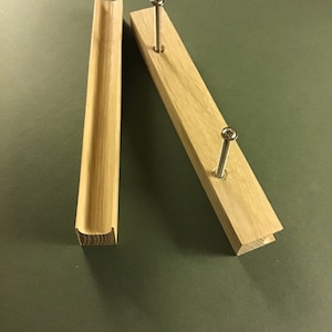 Peut inclure: Deux pièces de bois, l'une avec une rainure incurvée et l'autre avec deux vis, pour un projet de menuiserie.