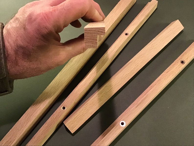 May include: Four wooden strips with rounded edges and pre-drilled holes. The strips are light brown in colour and appear to be made of oak.