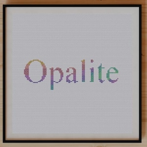 Puede incluir: Una impresión enmarcada con la palabra "Opalite" en letras coloridas. La obra de arte está centrada en una superficie de madera clara, rodeada de plantas, un cuaderno y tijeras. La estética general es limpia y natural.