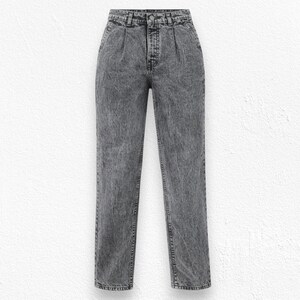 Puede incluir: Un par de vaqueros de mezclilla gris con lavado ácido. Los vaqueros tienen cintura alta, pliegues en la parte delantera y pernera recta. La mezclilla tiene un aspecto texturizado y un diseño clásico de cinco bolsillos.