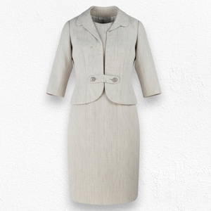 Peut inclure: Un ensemble deux pièces beige clair composé d'une robe fourreau sans manches et d'une veste courte assortie. La veste présente des manches trois-quarts, un col à revers et une patte de fermeture horizontale fixée par deux boutons.