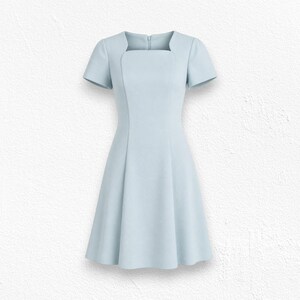 May include: A light blue dress featuring a square neckline, short sleeves, and a fitted bodice that transitions into a flared skirt. The garment includes a vertical seam detail down the front and a visible zipper closure at the center back neckline.