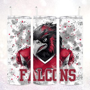 May include: A set of three white insulated tumblers with black straws. Each tumbler features a red and black illustration of a falcon with the word "Falcons" in red block letters. The background has a watercolor effect with red and gray splatters.