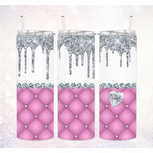 May include: Three stainless steel tumblers with a pink quilted design and silver glitter dripping down the sides. The center tumbler has a silver heart charm hanging from it.