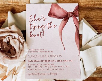 May include: A pink and white wedding invitation with a watercolor illustration of a red bow. The text reads "She's tying the knot!" and includes the bride's name, the date and time of the wedding, the location, and RSVP information.