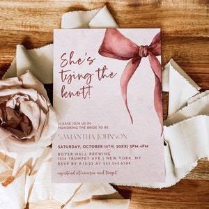 May include: A pink and white wedding invitation with a watercolor illustration of a red bow. The text reads "She's tying the knot!" and includes the bride's name, the date and time of the wedding, the location, and RSVP information.