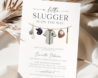 Peut inclure: Une invitation à une fête prénatale sur le thème du baseball. L'invitation présente un maillot de baseball, une batte de baseball, un gant de baseball et des balles de baseball suspendus à une corde à linge. Le texte de l'invitation indique "a little slugger is on the way!" et comprend le nom "Samantha Johnson" ainsi que la date et l'heure de la fête. L'invitation comprend également l'adresse de la fête et les informations de RSVP. Le texte au bas de l'invitation indique "registered at www.reallygreatbabyregistrysite.com".