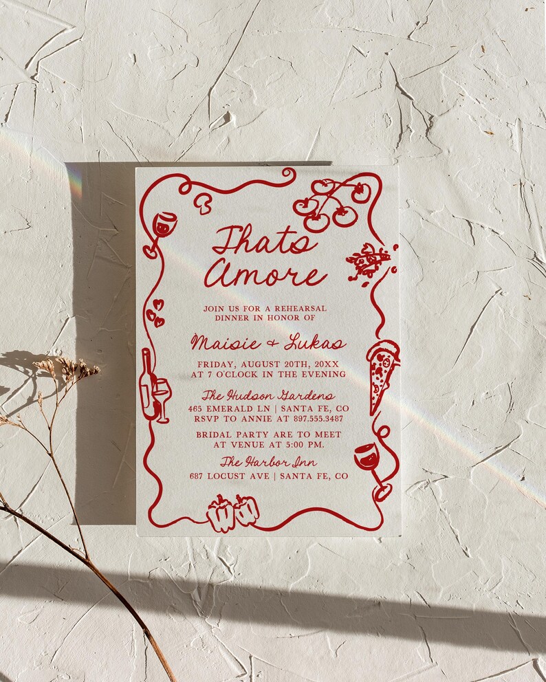 May include: Red and white invitation with a whimsical illustration of tomatoes, peppers, wine glasses, and pizza slices. The text reads "Thato Amore" and includes the names "Maisie & Lukas" for a rehearsal dinner. The event is at The Hudson Gardens on August 20th at 7:00 PM. The bridal party is to meet at The Harbor Inn at 5:00 PM.