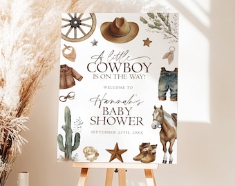 May include: A rectangular baby shower sign featuring watercolor illustrations of a wagon wheel, cowboy hat, cactus, horse, boots, and clothing. The text reads: A little COWBOY IS ON THE WAY! WELCOME TO Hannah's BABY SHOWER SEPTEMBER 25TH, 20XX.