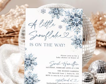 Op de afbeelding: Een witte rechthoekige uitnodigingskaart voor een babyshower met blauwe aquarel sneeuwvlokillustraties. De tekst luidt: A little Snowflake IS ON THE WAY! Please join us for a baby shower in honor of Sarah Hamilton, Saturday, February 20th at 2 PM.