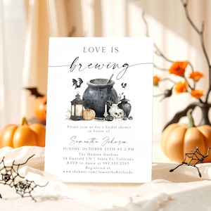 Puede incluir: Una tarjeta de invitación blanca con el texto "LOVE IS brewing" y una ilustración de acuarela de un caldero, calabazas, murciélagos y una calavera. La tarjeta es para una despedida de soltera, con detalles del evento.