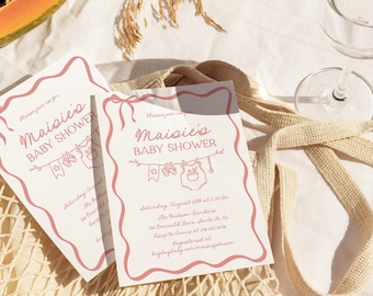 May include: Two white rectangular baby shower invitation cards with a wavy pink border. The text reads Maisie's BABY SHOWER, Saturday August 10th at 2:00 PM, The Hudson Gardens, 116 Emerald Lane, Santa Fe, Co, RSVP to Annie at 576 555 4576.