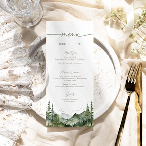 May include: A vertical rectangular paper menu featuring the word menu in script, an arrow icon, and sections for appetizers, main course, and sweets. The bottom of the card displays a watercolor illustration of green pine trees and mountains.
