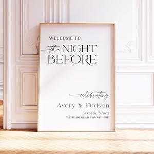 Pu&ograve; includere: Un cartello bianco incorniciato in oro, con la scritta "WELCOME TO the NIGHT BEFORE celebrating Avery & Hudson OCTOBER 10, 2026 WE'RE SO GLAD YOU'RE HERE!" in elegante corsivo nero. Il cartello &egrave; appoggiato a un muro bianco.