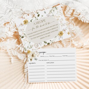 K&ouml;nnte beinhalten: Eine druckbare Rezeptkarte mit floralem Design. Die Karte hat einen Bereich f&uuml;r den Rezepttitel, Zutaten, Anweisungen, Portionen, Vorbereitungszeit und Gesamtzeit. Der Text auf der Karte lautet "Ein Rezept f&uuml;r die Braut. Bitte schreibe dein Lieblingsrezept auf die beigef&uuml;gte Rezeptkarte und bringe sie zur Dusche mit, um sie mit der Braut zu teilen!"