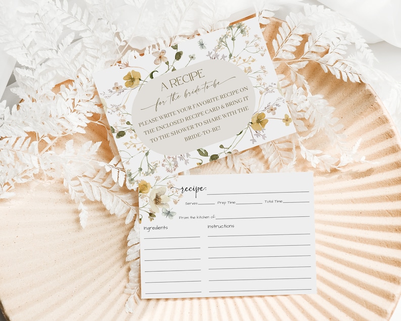 K&ouml;nnte beinhalten: Eine druckbare Rezeptkarte mit floralem Design. Die Karte hat einen Bereich f&uuml;r den Rezepttitel, Zutaten, Anweisungen, Portionen, Vorbereitungszeit und Gesamtzeit. Der Text auf der Karte lautet "Ein Rezept f&uuml;r die Braut. Bitte schreibe dein Lieblingsrezept auf die beigef&uuml;gte Rezeptkarte und bringe sie zur Dusche mit, um sie mit der Braut zu teilen!"