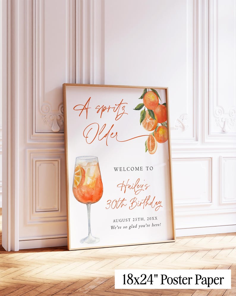 May include: A framed poster with a watercolor illustration of an Aperol Spritz cocktail and orange slices. The poster reads "A Spritz Older" and welcomes guests to Hailey's 30th birthday on August 25th, 20XX. The poster is 18x24 inches.