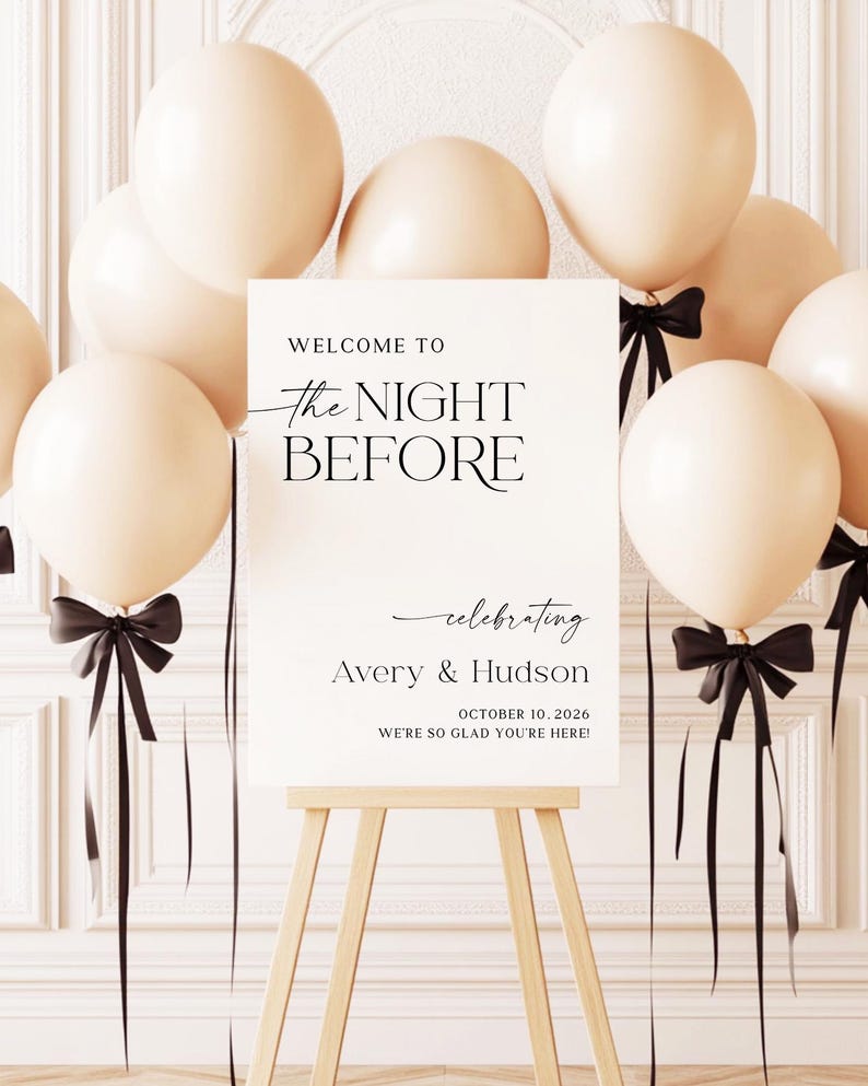 Pu&ograve; includere: Un cartello bianco su un cavalletto di legno, circondato da palloncini color crema e nastri neri. Il cartello recita "WELCOME TO The NIGHT BEFORE celebrating Avery & Hudson OCTOBER 10, 2026 WE'RE SO GLAD YOU'RE HERE!"