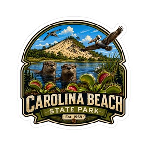 May include: A die-cut sticker featuring a landscape of Carolina Beach State Park with two otters in water, Venus flytraps in the foreground, and pelicans flying above a sandy dune. The text reads CAROLINA BEACH STATE PARK Est. 1969.