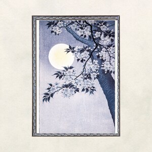 May include: A framed print of a Japanese woodblock print depicting a branch of a cherry blossom tree with white flowers against a pale blue background with a full moon.