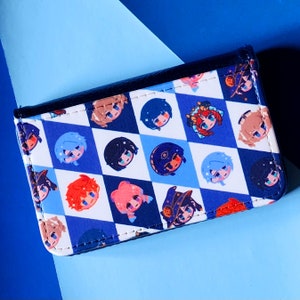 May include: A rectangular wallet with a black border and a blue and white checkered pattern. The pattern features cartoon character faces with various hair colors. The wallet is closed and appears to be made of a synthetic material.