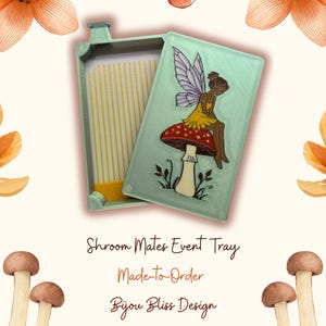 May include: A light green rectangular tray with a matching lid featuring a fairy sitting on a red mushroom. The interior of the tray has vertical yellow lines. Text on the image reads: Shroom Mates Event Tray, Made-To-Order, Bijou Bliss Design.