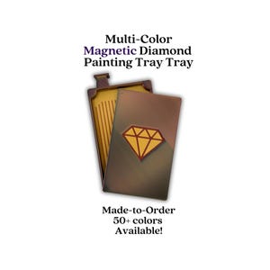 May include: A multi-color magnetic diamond painting tray with a rectangular shape and a gold-toned interior featuring vertical grooves. The exterior cover is a dark metallic bronze color with a prominent gold diamond-shaped icon centered on the front.