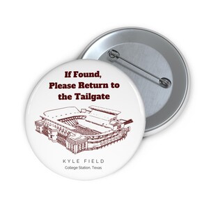 Puede incluir: Botón blanco con texto marrón que dice "Si se encuentra, por favor devuelva al tailgate". Un contorno marrón de Kyle Field, un estadio de fútbol, está debajo del texto. El texto "KYLE FIELD" y "College Station, Texas" están debajo del contorno del estadio.