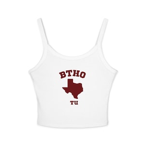 May include: White tank top with thin straps. The front features the maroon text "BTHO" above a maroon outline of the state of Texas, with "TU" below. The top is a casual style.