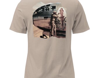 May include: Tan t-shirt featuring a vintage-style graphic on the back. The graphic depicts a WWII-era bomber plane with a pin-up girl and the text "Little G". The design includes a soldier and a ladder.