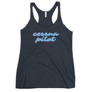 Puede incluir: Camiseta sin mangas azul marino oscuro con la frase "cessna pilot" en escritura azul claro en la parte delantera. El texto tiene un efecto degradado, pasando de un tono azul más oscuro a uno más claro.