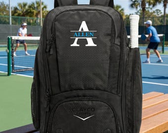 May include: A black sports backpack with a textured honeycomb pattern, featuring a white letter A with the name ALLEN in blue text across the center. The bag includes a side pocket holding a white tennis racket and a logo reading CLAYCO SPORTS.