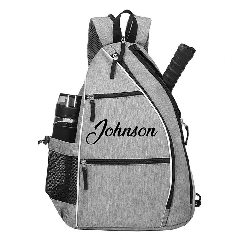 A gray and black sports backpack with the name "Johnson" printed on it.