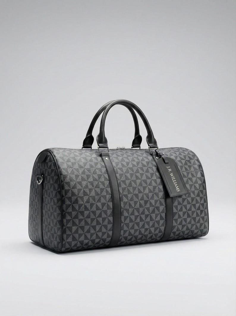 A black and gray patterned duffel bag with two handles and a tag.