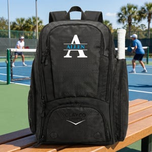 May include: A black sports backpack with a textured honeycomb pattern, featuring a white letter A with the name ALLEN in blue text across the centre. The bag includes a side pocket holding a white tennis racket and a logo reading CLAYCO SPORTS.