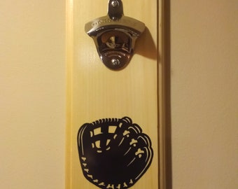 May include: A wooden wall mounted bottle opener with a baseball glove silhouette. The bottle opener is silver and has a chrome finish.