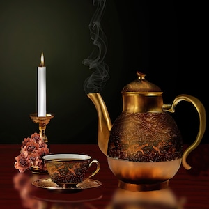 Könnte beinhalten: Eine goldene Teekanne mit aufwendigen Verzierungen steht auf einem Holztisch neben einer brennenden Kerze und einer Tasse Tee. Die Teekanne hat einen Ausguss und einen Griff, und die Kerze steht in einem goldenen Kerzenleuchter. Die Teetasse steht auf einem Untersetzer mit Blumenmuster.