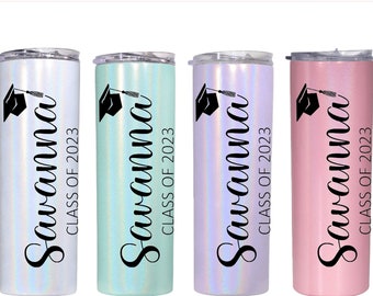 May include: Four stainless steel tumblers with a holographic finish. Each tumbler has a black graduation cap graphic and the text "Savanna Class of 2023". The tumblers are in the colors white, light blue, purple, and pink.