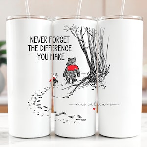 May include: White insulated tumbler with a straw, featuring a black and red illustration of Winnie the Pooh and Piglet. The tumbler has the text "NEVER FORGET THE DIFFERENCE YOU MAKE" and a personalized signature. A perfect gift for teachers.