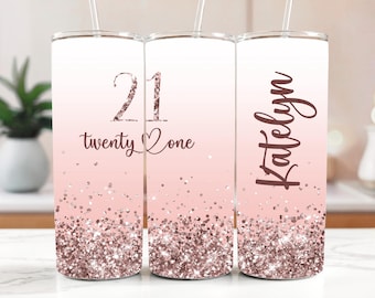 May include: Three stainless steel tumblers with straws. The tumblers have a gradient design, transitioning from white to pink, with rose gold glitter at the bottom. One tumbler reads "21 twenty one", and another reads "Katelyn".
