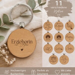 Può includere: Un portachiavi in legno con un anello argentato e un ciondolo rotondo in legno. Il ciondolo presenta l'incisione "Erzieherin mit Herz" e un piccolo cuore. L'immagine mostra anche 11 diversi design.