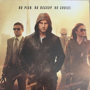 May include: Movie poster for Mission: Impossible - Ghost Protocol starring Tom Cruise. The poster features a dark background with a cityscape in the distance. Tom Cruise is in the center of the poster, wearing a black leather jacket and a hooded sweatshirt. He is looking directly at the viewer. The text "NO PLAN. NO BACKUP. NO CHOICE." is at the top of the poster. The title of the film, "MISSION: IMPOSSIBLE - GHOST PROTOCOL", is in large, white letters at the bottom of the poster.