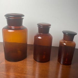 Three Vintage Amber Glass Apothecary Jars With Glass Stoppers