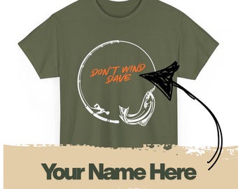 May include: Olive green t-shirt with a white graphic of a fishing rod and a fish, with the text "DON'T WIND DAVE" in orange. The bottom of the shirt has the text "Your Name Here" in dark green.