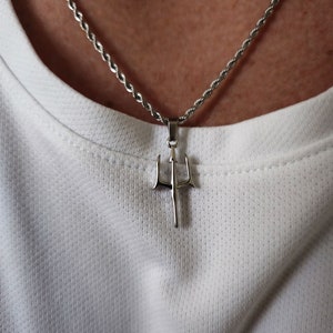 May include: A silver chain necklace with a trident pendant. The chain is a twisted rope style.