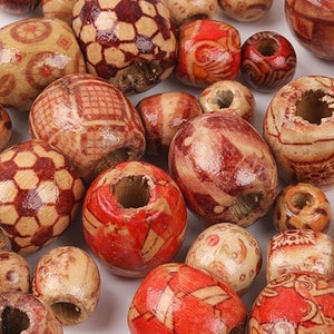 Op de afbeelding: Een verzameling houten kralen met verschillende geometrische en bloemmotieven in tinten bruin en rood.