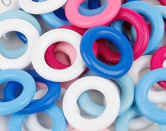 May include: A collection of colorful wooden rings in shades of white, pink, blue, and red, with a diameter of 32mm. The rings are scattered on a white plate. The text "Follow your heart" is visible on the plate.