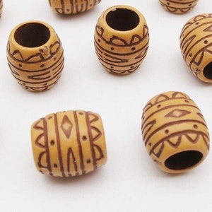 May include: Twenty brown wooden hair beads with a geometric pattern. The beads are about 1 inch long and have a diameter of about 1/2 inch.