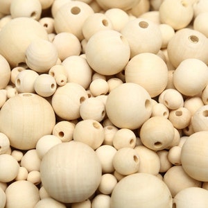 May include: A large assortment of natural wood beads in various sizes. The beads are round and have a hole drilled through the center. They are perfect for crafting projects, jewelry making, and home decor.